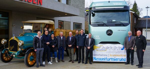 Drei Generationen Keller-Altherr, Mitglieder der Raiffeisen-Geschäftsleitung und vom Fest-OK, mit Nutzfahrzeugen aus verschiedenen Epochen. Bild: OK UniforMade2025 | Musikgesellschaft Nesslau-Neu St.Johann